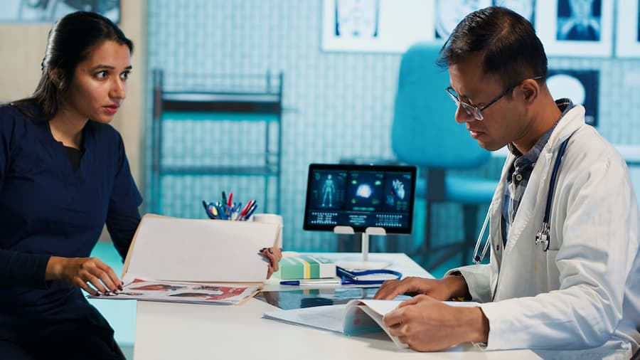 physician meeting with patient discuss medical test results cabinet (1)